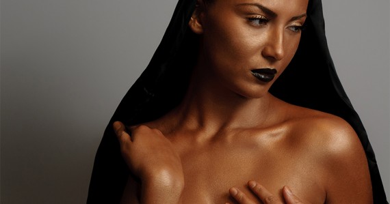 Young woman with cape and bronzed skin