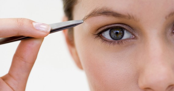 Woman plucking eyebrow
