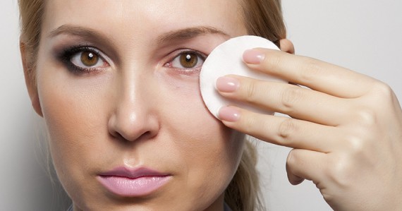 Caucasian female removing the make up from her face
